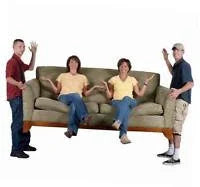 Two men carrying a beige sofa with a woman sitting comfortably in the middle against white background